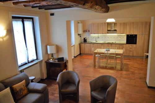 a living room with a table and chairs and a kitchen at CORTE MORONA in Marmirolo