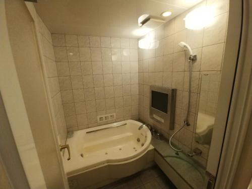 a bathroom with a tub and a shower with a tv at Hotel Allure (Adult Only) in Nagoya