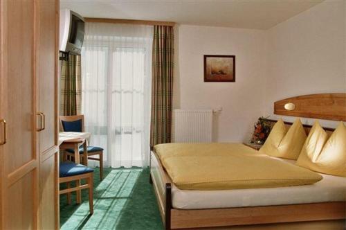 a bedroom with a bed and a desk in a room at Jugendgästehaus Tauernruh in Radstadt