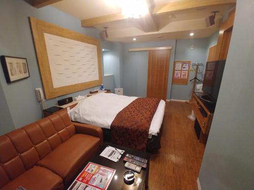 a hotel room with a bed and a couch at Hotel Allure (Adult Only) in Nagoya