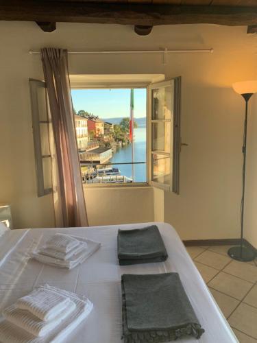 um quarto com uma cama e uma janela grande em -Ortaflats- Appartamento Belvedere em Orta San Giulio