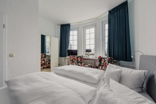ブラウンラーゲにあるLandhotel Villa Forestaのベッドルーム1室(ベッド1台、椅子2脚付)