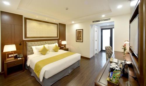 a hotel room with a bed and a desk at Garco Dragon Hotel 2 in Hanoi