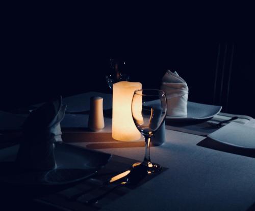 a table with a candle and a wine glass at Villa 252 Kosgoda in Kosgoda