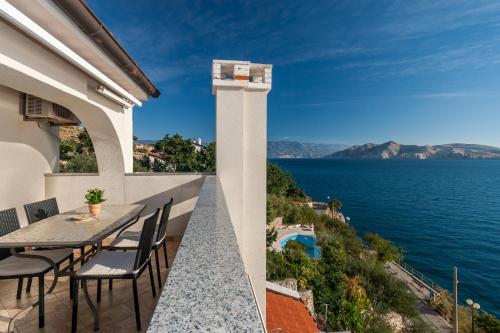 a balcony with a table and chairs overlooking the water at Lori in Baška