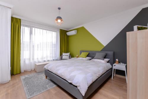 ein Schlafzimmer mit einem großen Bett und grünen Wänden in der Unterkunft The Spot - fully equipped, central, modern studio by Flat Mаnager in Sofia