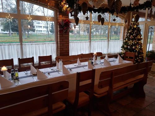 a long table with a christmas tree in a room at Sabbia Ristorante - Reštaurácia a Ubytovanie Prievidza in Prievidza
