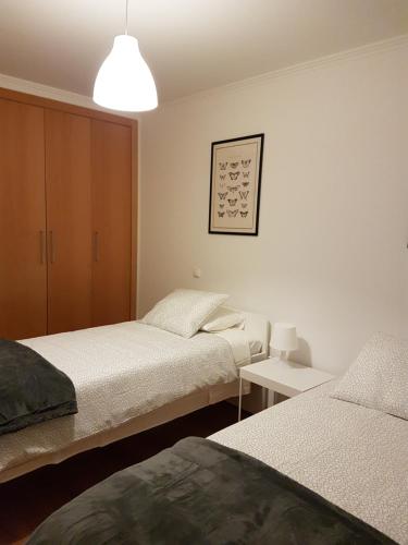 a bedroom with two beds and a lamp at Quinta dos Lombos in Carcavelos