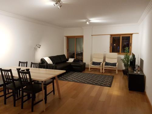 een woonkamer met een tafel en een bank bij Quinta dos Lombos in Carcavelos