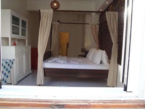 1 dormitorio con 1 cama grande y cortinas en Korthi central appartment by the seaside., en Órmos