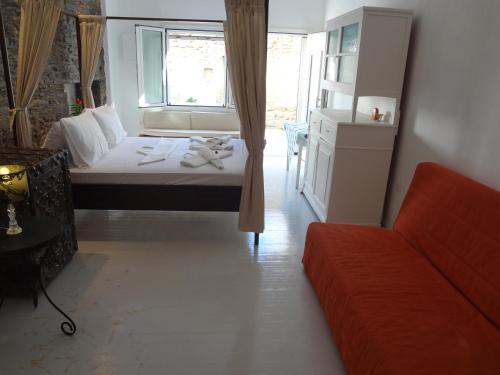 Un dormitorio con una cama y un sofá y una ventana. en Korthi central appartment by the seaside., en Órmos