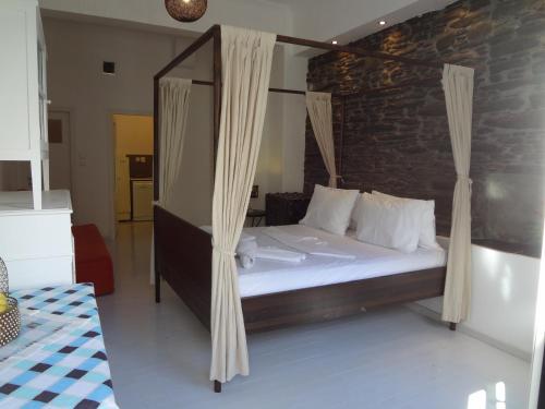 1 dormitorio con cama con dosel y almohadas blancas en Korthi central appartment by the seaside., en Órmos