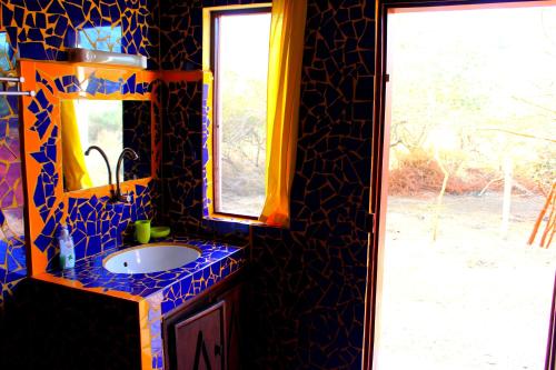 a bathroom with a sink and a mirror and a window at Le Lodge Dalaal Diam in Somone