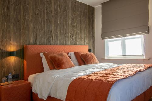 1 dormitorio con 1 cama grande y cabecero naranja en De Kaleihoeve, en Bavikhove