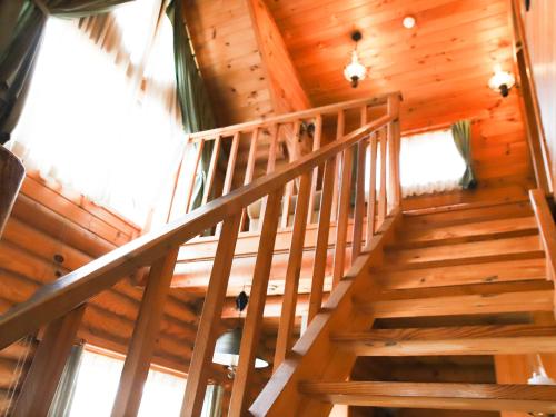 a staircase in a cabin with wooden walls and ceilings at The Day Osaka in Osaka