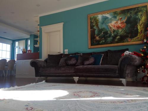 a living room with a couch and a painting on the wall at Olive Tree in Tirana