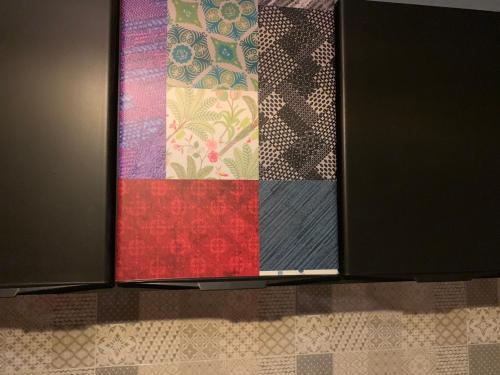 a quilt hanging on a kitchen cabinet in a kitchen at FiumicinoA57 in Fiumicino