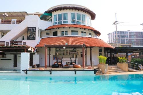 a building with a swimming pool in front of a building at My Way Hua Hin Music Hotel SHA Extra Plus in Hua Hin