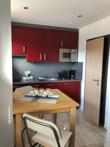 a kitchen with a wooden table and red cabinets at City-Apparte ONE Zentrales & komfortables Wohnen in Gronau in Gronau