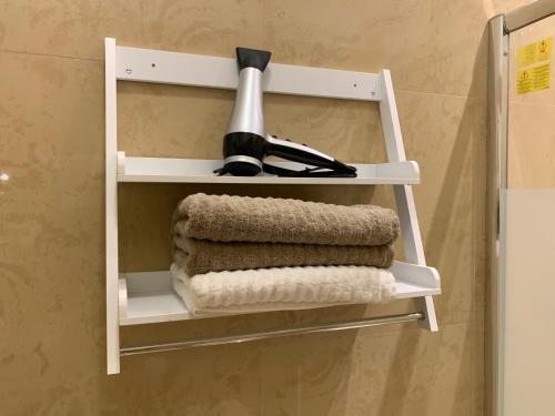a white towel rack with a hair dryer and towels at FiumicinoA57 in Fiumicino