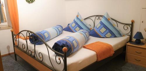 a bed with blue and white pillows on it at Ferienwohnungen Haus Seeblick in Bad Staffelstein