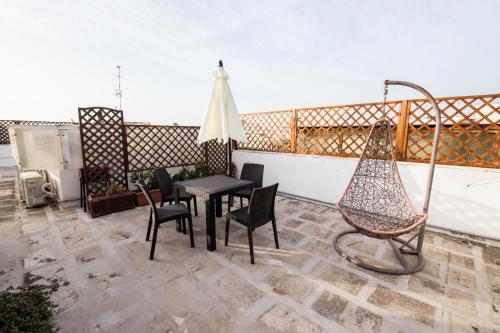 eine Terrasse mit einer Hängematte sowie einem Tisch und Stühlen in der Unterkunft Casa Vacanze Capitano in Porto Cesareo