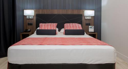 a bedroom with a large bed with two pillows at Itaca Artemisa by Soho Boutique in Seville