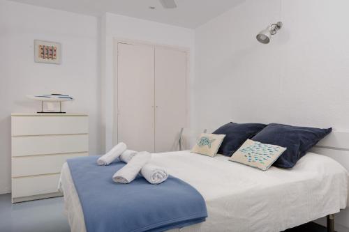 1 dormitorio con 1 cama con almohadas azules y blancas en Sa Tuna 1- Cal Guarda, en Begur
