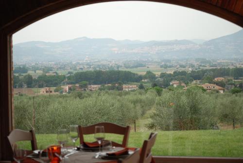 a table with a view of a valley from a window at Tenuta Del Perugino in Bettona