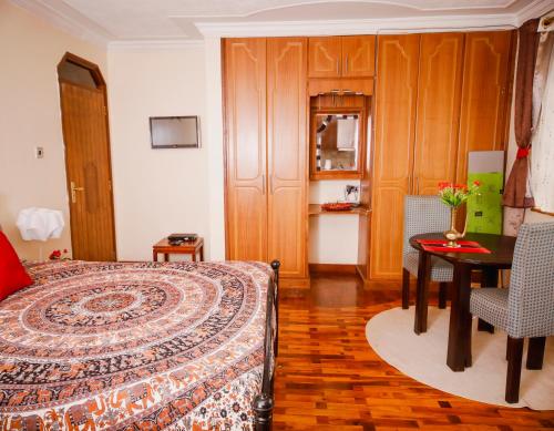 - une chambre avec un lit, une table et une table dans l'établissement Sherry Homes - Kwetu, à Nairobi