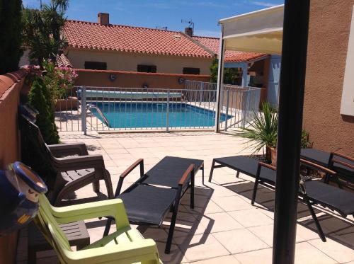 un patio avec des chaises et une piscine dans l'établissement Bord de mer villa 8pers piscine au sel chauffée, à Saint-Cyprien