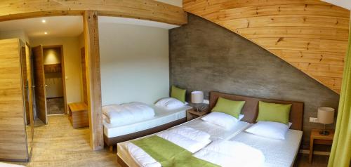 a bedroom with a large white bed with green pillows at Camping Bissen in Esch-sur-Sûre