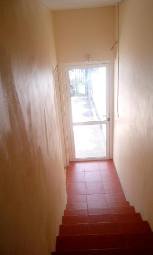 a door leading to a hallway with a staircase with a glass door at Chetty Tourist Residence in Pereybere