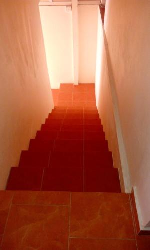 a hallway with a staircase with a red floor at Chetty Tourist Residence in Pereybere