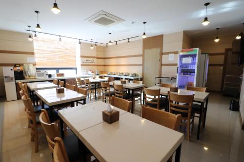 a dining room with tables and chairs in a restaurant at Hotel Airport in Busan