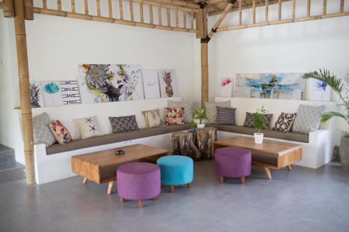a room with two tables and chairs and a couch at Jago Gili Air in Gili Islands