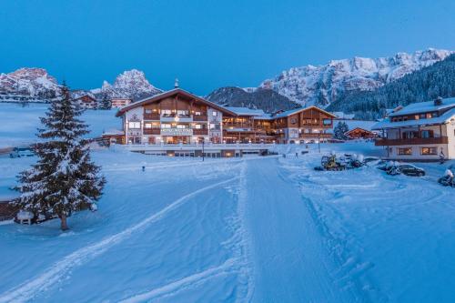 a resort in the snow with a christmas tree at Hotel Welponer in Selva di Val Gardena