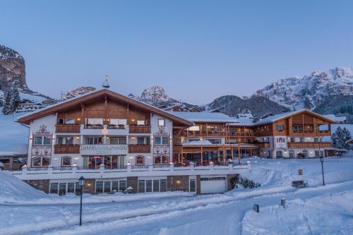 a ski lodge in the mountains with snow at Hotel Welponer in Selva di Val Gardena