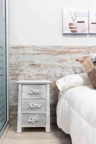 a bedroom with a bed and a night stand next to a drawer at Urban Sabadell in Sabadell