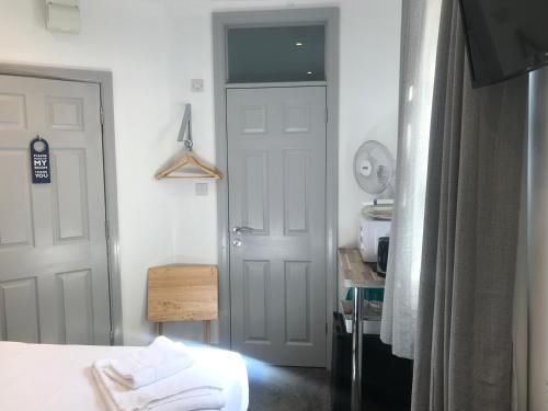 a room with a bed and a door and a table at The Lake House in Plymouth