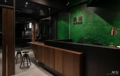 a green wall in a restaurant with a bar at Art Zone 2 in Hualien City