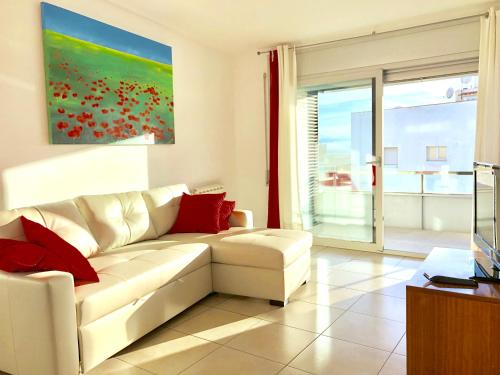 a living room with a white couch and red pillows at Apartament Familiar Av. Tarragona in Roses