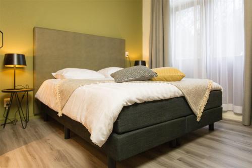 ein Schlafzimmer mit einem großen Bett mit weißer Bettwäsche und Kissen in der Unterkunft Bed & Breakfast Van Marion in Oostvoorne