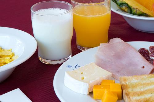 a plate of food with cheese cheese and milk at GHT Costa Brava & Spa in Tossa de Mar