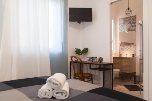 ein Schlafzimmer mit einem Bett und einem Schreibtisch mit einem Stuhl in der Unterkunft Casa Vacanze Eco del Mare in Agrigento