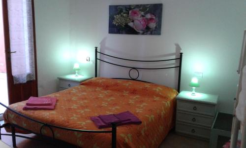 una camera con un letto con due comodini e due lampade di L'Onda Blu a Domus de Maria