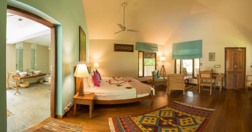 a bedroom with a bed and a living room at Neeleshwar Hermitage in Nīleshwar