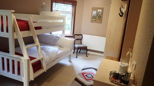 a living room with two bunk beds and a desk at Arrochoile in Balmaha