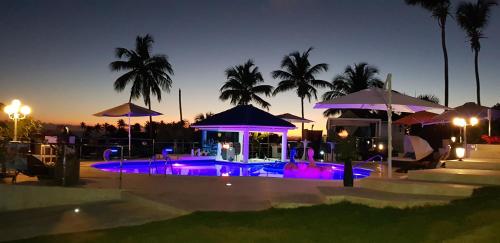 a swimming pool with purple lights at night at casaenjoysamana in Los Naranjos