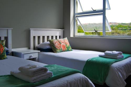 a bedroom with two beds with towels on them at Aloe Ridge in Mossel Bay
